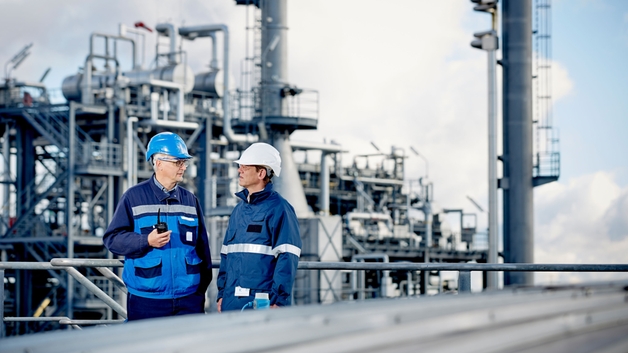 Técnicos expertos delante de una refinería