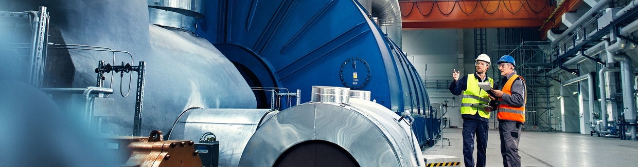 Primer plano de un ingeniero frente a una turbina de una central eléctrica