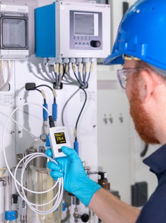 Un hombre comprueba el valor de la conductividad con el equipo CML18 en un punto de medición de la planta una producción