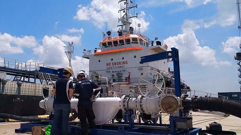 Un skid de pruebas con medidor maestro de Endress+Hauser delante de un buque cisterna en el puerto