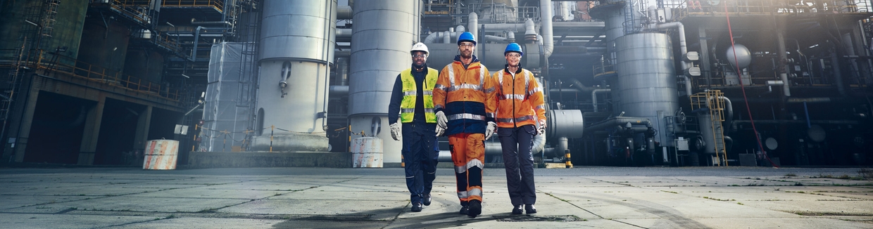 Fotografía en primer plano de una  ingeniera de Endress+Hauser delante de una refinería
