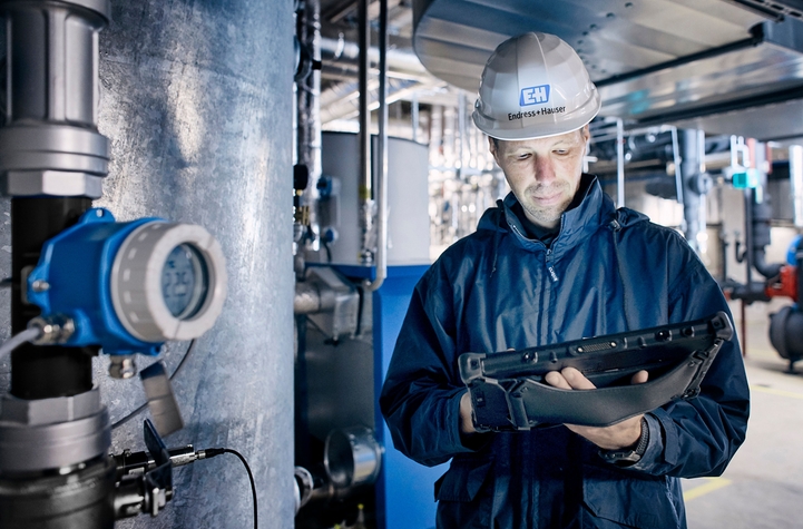 Transmisor de temperatura iTEMP TMT142B junto a un empleado de Endress+Hauser sobre el terreno