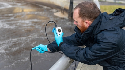 Un hombre comprueba un punto de medición de OD con un medidor de oxígeno portátil